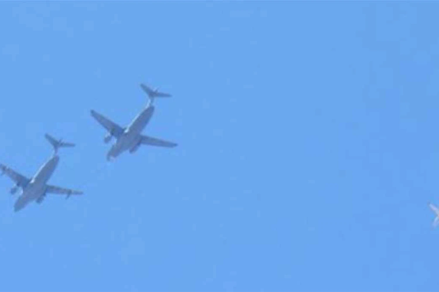 Um KC-390 abastecendo outro KC-390, acompanhados por um Phenom na "paquera"