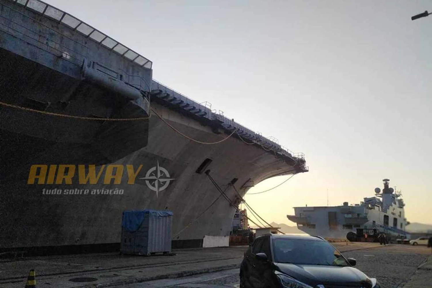 Sem cuidados, o velho porta-aviões contrasta com seu sucessor, o NAM Atlântico, ao fundo (AIRWAY)
