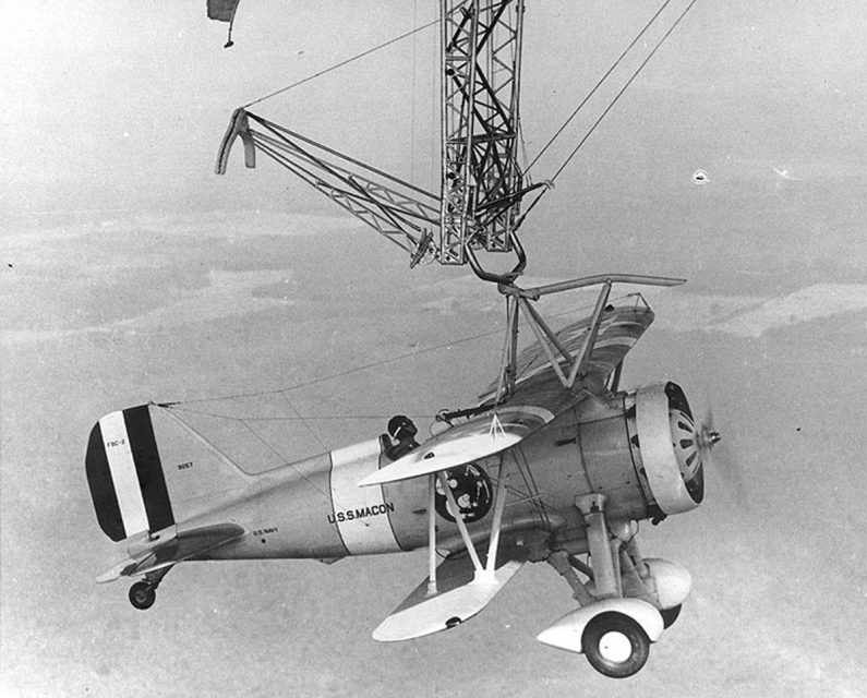 Olho no trapézio! Piloto completa o engate com o caça no USS Macon 