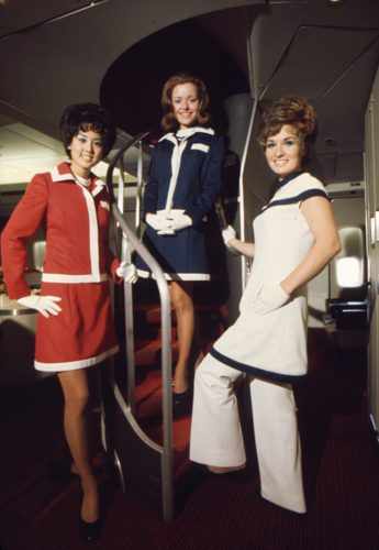 Comissária com o uniforme da década de 1970, na escada do Boeing 747 (AA)