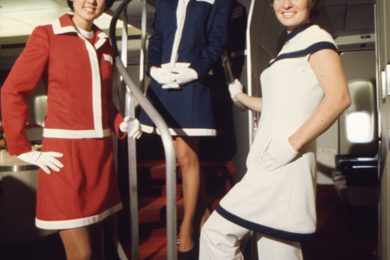 Comissária com o uniforme da década de 1970, na escada do Boeing 747 (AA)