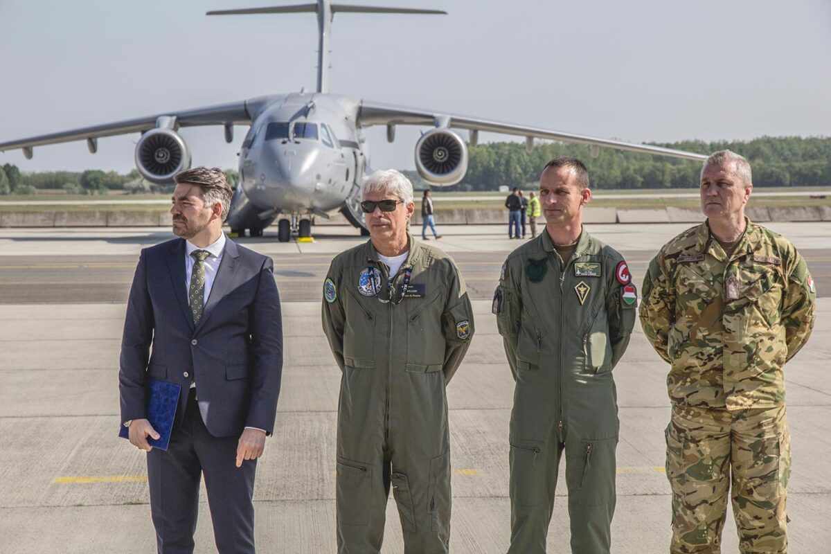 Zsolt Kutnyánszky, Secretário de Estado do Ministério da Defesa Nacional, William Souza, piloto de testes da Embraer, Major Viktor Langó, Subcomandante Interino da Brigada, e Coronel György Grécs, Chefe do Estado-Maior