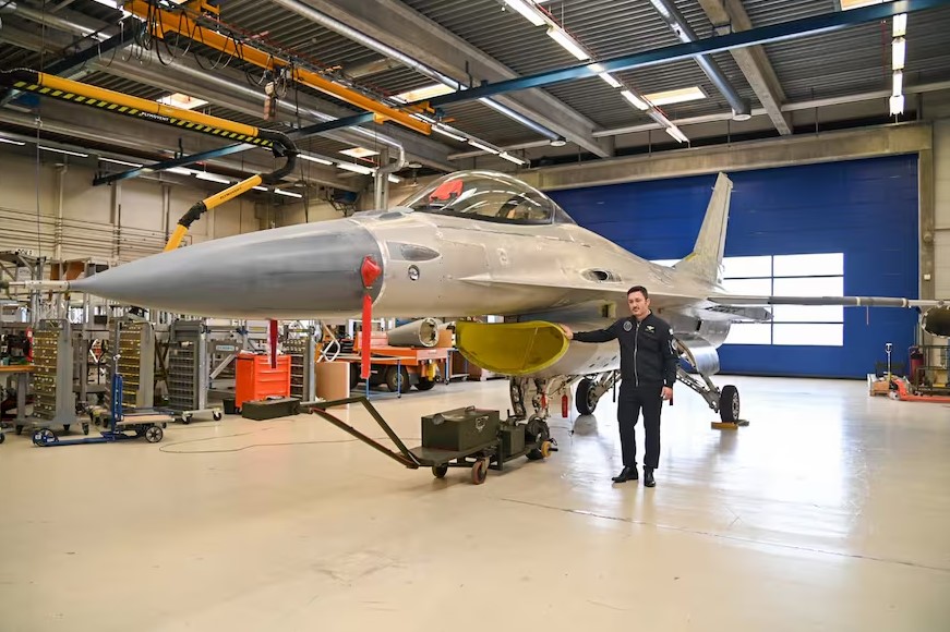 Luis Petri, ministro da Defesa da Argentina, posa ao lado de um F-16 na Dinamarca (divulgação)